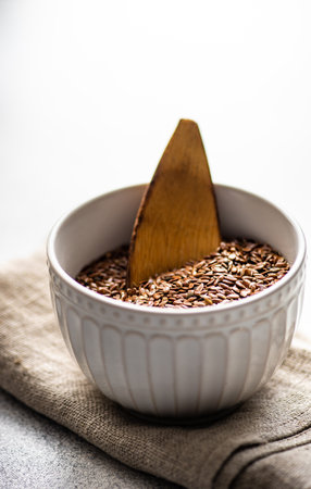 Bowl with organic flax seeds as a healthy cooking concept on concrete backgroundの写真素材
