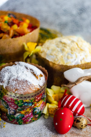 Easter food concept with traditional cake and colored eggs decorated with spring flowers