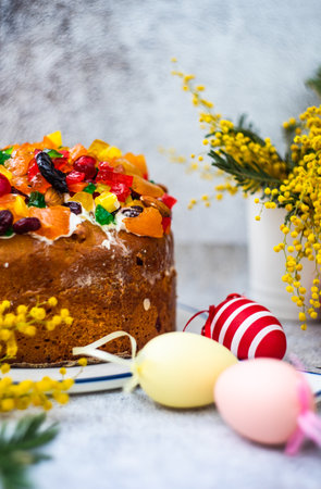 Easter food concept with traditional cake and colored eggs decorated with spring flowers