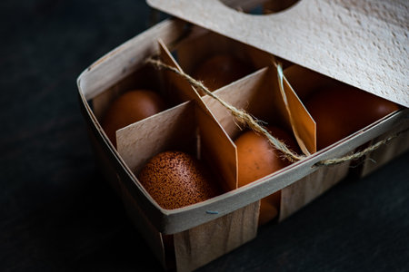 Healthy uncooked eggs in rustic box on wooden table