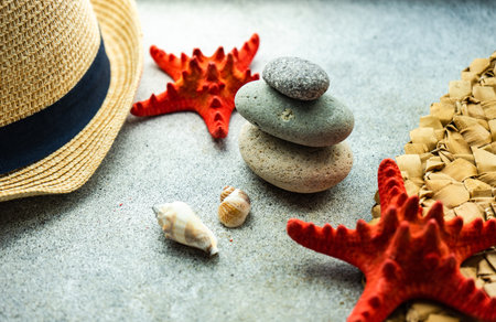 Summer background flat lay with straw hat and sea starsの写真素材