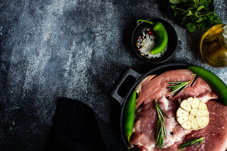 Cooking concept with pork meat steak, spices and herbs on concrete backgroundの写真素材