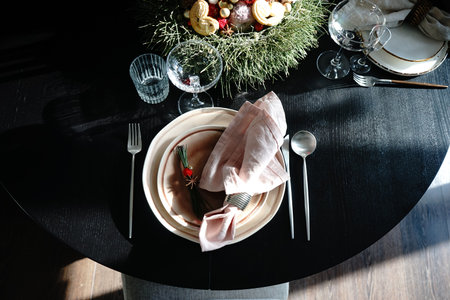 Table setting for festive Christmas dinner on black wooden table