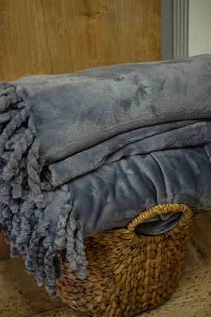 Straw basket full of warm plaidsの写真素材