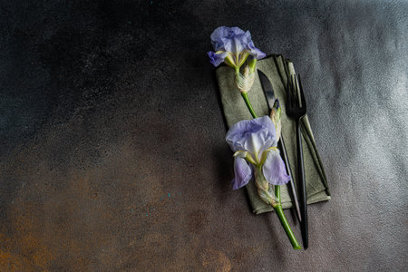 Table setting with pale blue iris flowers n dark concrete backgroundの写真素材