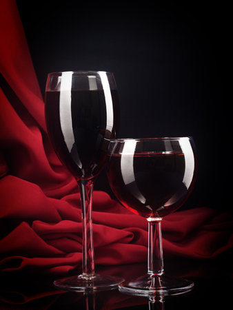 Red wine glass and bottle on a silk background.の写真素材