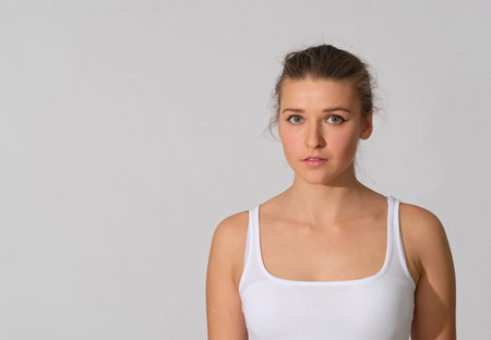 Nude make-up and perfect skin on light background. She dressed in white T-shirt. Fashion, yoga, art...