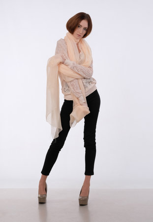 She dressed on elegant lace blouse and translucent beige shawl on the shoulders. She looking forward. Hands near chest.の写真素材