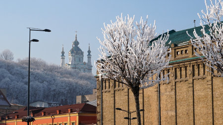 at frozen day: trees in the snow against the blue sky,  buildings and St. Andrew churchの写真素材