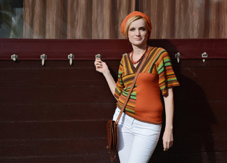 Style of the 1970s. A beautiful long-haired blonde in retro clothes. white tights, model hair, high heels, motley accessories, striped blouseの写真素材