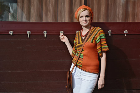 Style of the 1970s. A beautiful long-haired blonde in retro clothes. white tights, model hair, high heels, motley accessories, striped blouseの写真素材