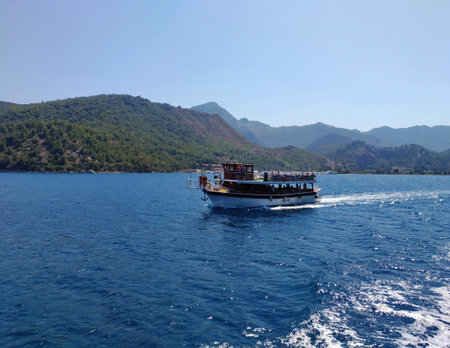 Sea, sky, boat, summer, sunny day, yacht near picturesque hilly coast. Blue and gree pure natural colors. The concept of  water tripsの写真素材