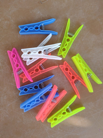 Multi-colored clothes pegs on a neutral background. Magenta - blue, green - yellow, bright fluorescent colorsの写真素材
