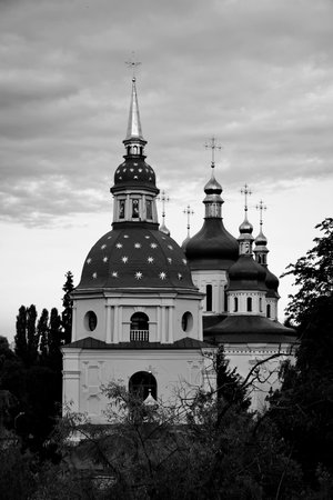 Evening cityscape from the right bank of the Dnipro river. A splendid view from the National Botanic Garden over the Vydubychi Monastery with blue dome with stars.の写真素材