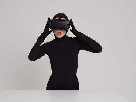 An excited girl experiencing the virtual reality in the VR headset. Hi-Tech gadgets for geeks and technical enthusiasts. Virtual reality helmet for entertainment.の写真素材