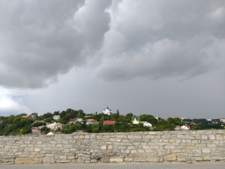 Church with blue dome, dramatic storm, clouds landscape, panoramic view with small details, shot in the city of Kamenets-Podolsky near the fortress.の写真素材
