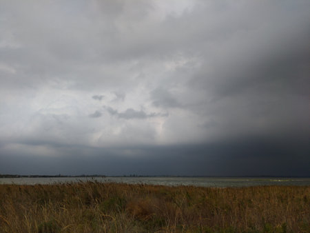 Dramatic storm sky panorama wide-angle landscape, sea, clouds, fieldの写真素材