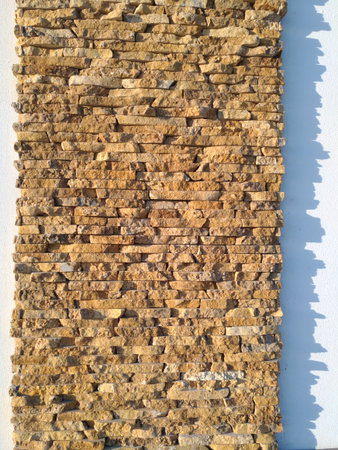 Bricks on decorative wall outdoors, nice texture with beatiful blue shadow from direct warm evening sunの写真素材