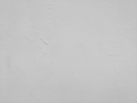 White-gray plastered surface, painted. Wall with weathered areas of peeling paint with small cracks little contrast perfectly as background for illustration space for textの写真素材