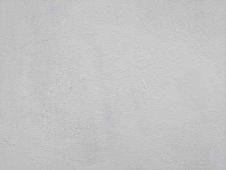 White-gray plastered surface, painted. Wall with weathered areas of peeling paint with small cracks little contrast perfectly as background for illustration space for textの写真素材