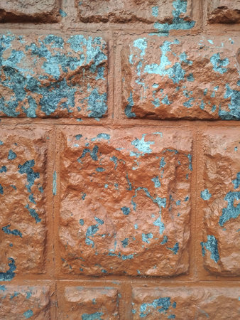 Textured facing of the exterior of the building from large square and rectangular blocks, coarsely hewn folded in the style of brickwork, with a peeling surface, worn out by time, retroの写真素材