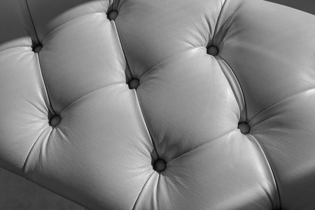 a fragment of a leather-covered sofa in close-up; braces-buttons, tightening material, rhombic structureの写真素材