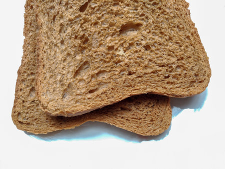 Slice of bread. The malt bread toasts that have just been extracted from the toaster are hot. on white background, close-up, macro, visible textureの写真素材