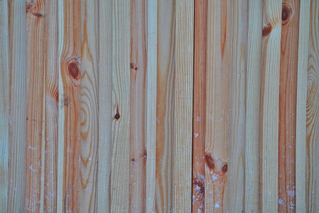 Fragment of a wooden fence in winter with a snow