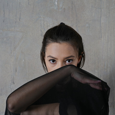 Woman dancer portrait in motion with a cloth against the wall