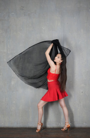 Woman dancer in motion with a cloth against the wallの写真素材