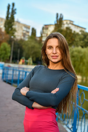 Confident Young Woman in Urban Park Setting on a Clear Dayの写真素材