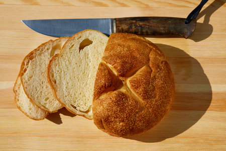 sliced bread lying on the table and knife top viewの写真素材