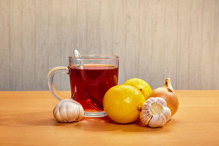 On the table mug with tea lemons garlic onionsの写真素材