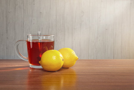 On the table a mug of tea with lemonsの写真素材