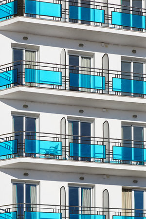 Several floors of a white building with blue balconiesの写真素材