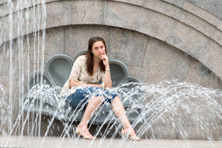 Attractive woman near fountainの写真素材