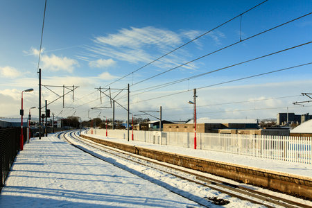 Winter Railway Scene.  The snow covered platforms of Penrith railway station in Cumbria, England pictured on a sunny winter morning.の写真素材