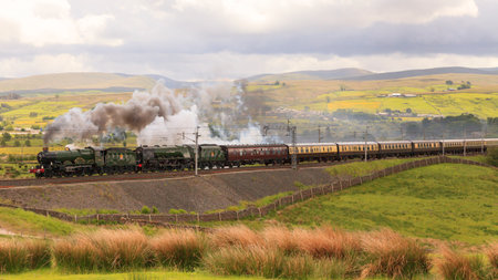 The Cumbrian Conqueror.  Preserved steam locomotives 5043 Earl of Mount Edgcumbe and 46233 Duchess of Sutherland head the Cumbrian Conqueror northbound through Tebay, Cumbria.のeditorial素材