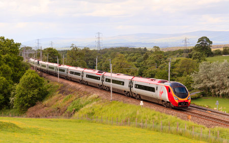 Virgin Pendolino.  A Virgin Pendolino heads north through Hackthorpe, Cumbria.  Virgin trains have operated the UK west coast main line rail franchise since 1987.のeditorial素材