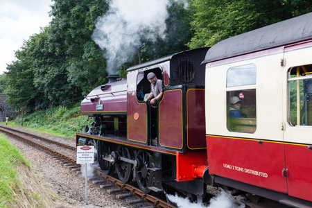 Newby Bridge Halt.  Victor, a preserved steam locomotive, departs Newby Bridge Halt.  The halt is on the Lakeside and Haverthwaite Railway in Cumbria, northern England.のeditorial素材