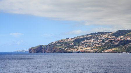 Canico Seafront.  The seafront of Canico on the Portuguese island of Madeira.  Capital city Funchal can be seen beyond the headland.の写真素材