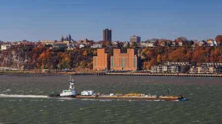 The tugboat Peter F. Gellatly pushes a barge up the Hudson River.  The New Jersey waterfront can be seen in the background.のeditorial素材