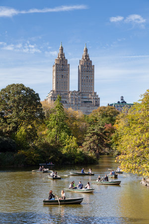 The public enjoy rowing their boats on the Lake in Central Park, New York City.  In the background...