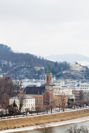 A winter view across the Salzach River, Salzburg in Austria.  In the foreground is the Protestant parish Salzburg Christ Church.のeditorial素材