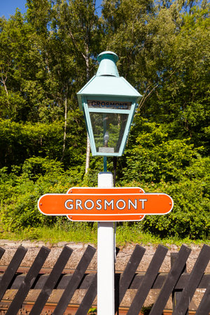 A close up of a traditional light and destination sign on the platform of Grosmont Station, on the North Yorkshire Moors Railway.のeditorial素材