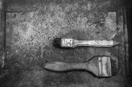 Black and white of old used paint brush on metal plateの写真素材