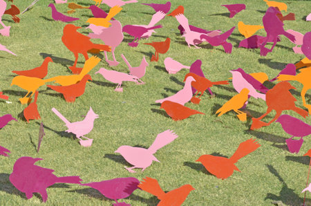 Color plastic birds on grass floorの写真素材
