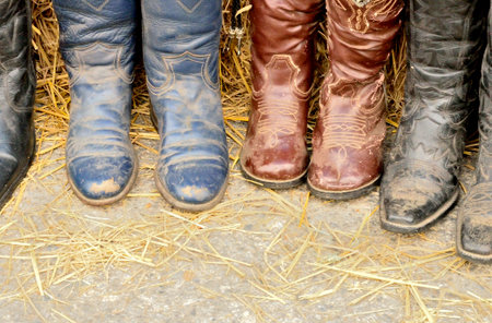 Dirty cowgirl boots on the floorの写真素材