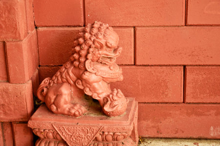 Red lion sculpture with red brick wallの写真素材