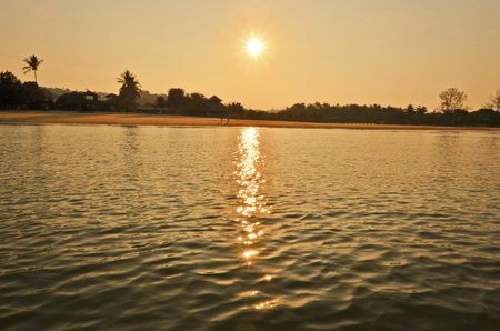 Sunset over the water and the sandの写真素材